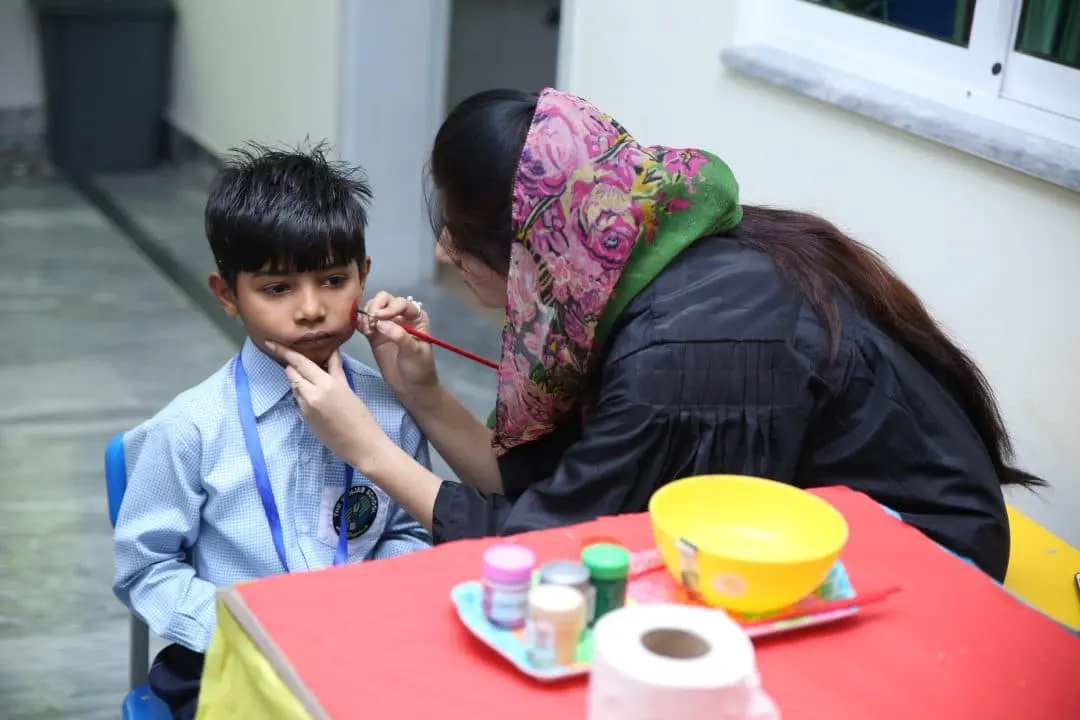 A teacher painting a child’s face on activity day